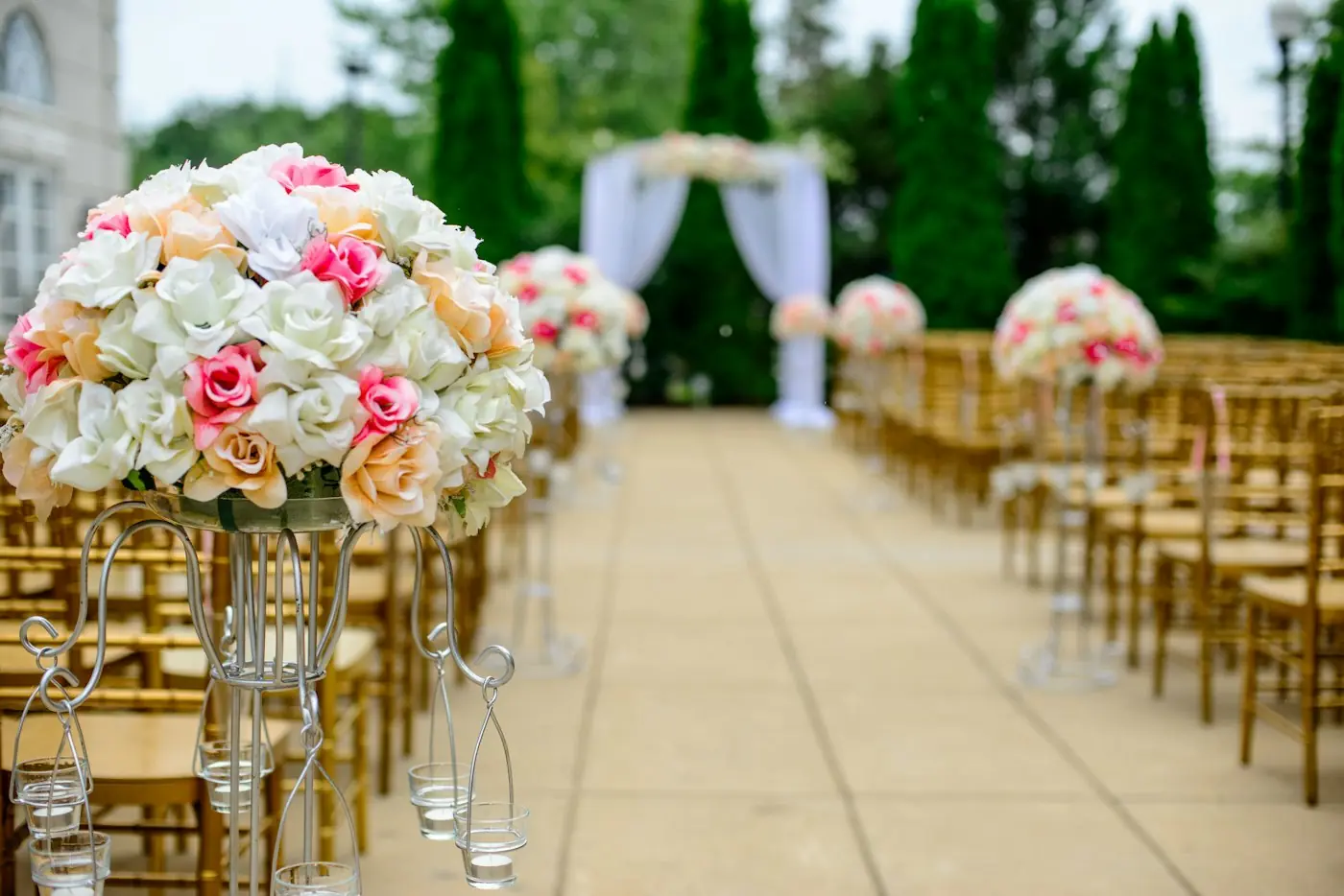 Ceremony aisle lined with roses and gold chairs